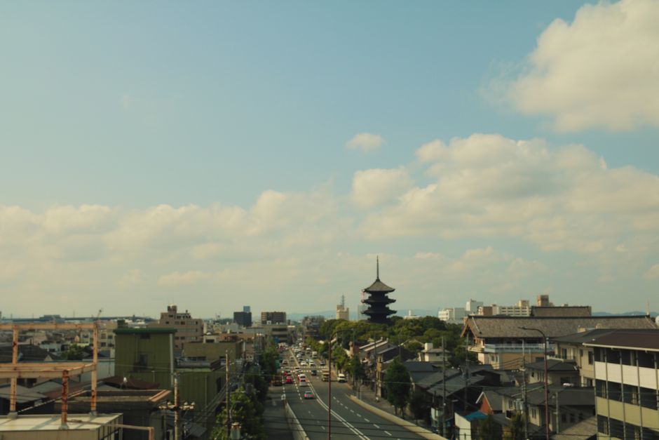 Explore the iconic skyline of Kyoto with the striking Yasaka Pagoda in the foreground on a sunny day.
